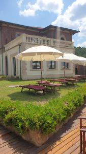 two picnic tables with umbrellas in front of a building at Cala Dei Mori in Livorno