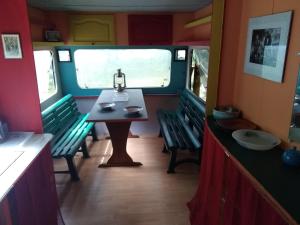 una mesa y sillas en un vagón de tren con ventana en Les yourtes de Bascot en Vaylats
