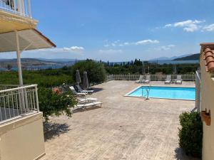 a swimming pool with a view of a house at Leonidas Resort in Ermioni