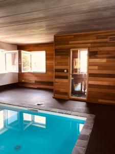 una habitación con piscina y una casa en Le Doux Ny, en Stoumont