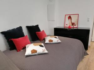 een slaapkamer met een bed met rode en zwarte kussens bij Soriers in Aspremont