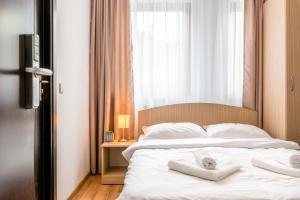 a bedroom with a bed with two towels on it at Pensiunea Armonia in Nădăşelu