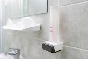 a white blow dryer on the wall of a bathroom at Pensiunea Armonia in Nădăşelu