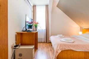 a small bedroom with a bed and a window at Pensiunea Armonia in Nădăşelu
