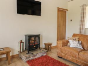 a living room with a stove and a couch at Crabtree Cottage in Scarborough