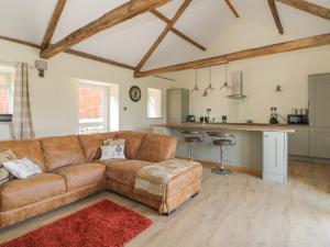 a living room with a brown couch and a kitchen at Crabtree Cottage in Scarborough