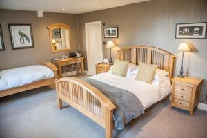 1 dormitorio con 2 camas, 2 mesas y espejo en Mitton Hall Hotel, en Clitheroe