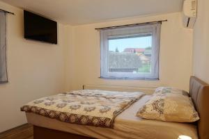 a small bedroom with a bed with a window at Apartments Laura FARM STAY in Podčetrtek