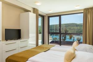a bedroom with a bed and a large window at Park Hill Residences in Rabac +155 photos