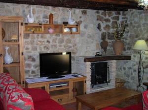 sala de estar con TV y chimenea en Casa Rural Sarmiento, en Cubillas de Santa Marta