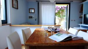 ein Esszimmer mit einem Holztisch mit Weingläsern in der Unterkunft Welcomely - Sardinian Stone House in Torre Grande