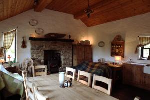 a dining room with a table and a fireplace at The Spinner's Cottage in Donegal