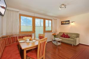 ein Wohnzimmer mit einem Tisch und einem Sofa in der Unterkunft Apart Sunshine in Längenfeld