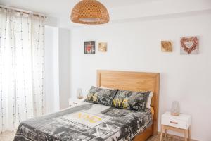 a bedroom with a bed with a wooden headboard at Una ventana al mar in Rota