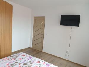 um quarto com uma cama e uma televisão de ecrã plano em Apartament Diana em Jurilovca