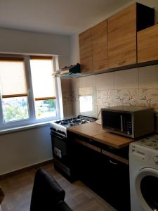 a kitchen with a stove and a microwave at Apartament Diana in Jurilovca