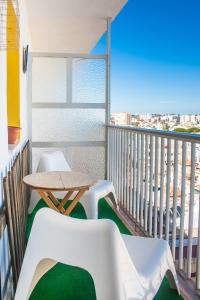 a balcony with a table and chairs and a view of the city at Una ventana al mar in Rota