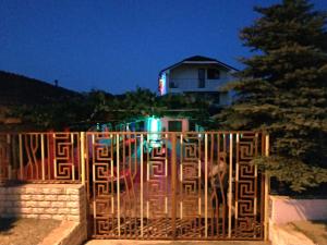 um homem parado atrás de um portão em frente a uma casa em Casa Elena em 2 Mai