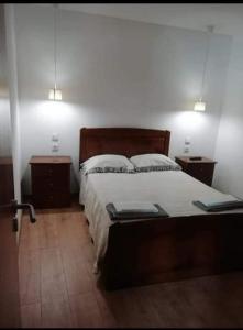 ein Schlafzimmer mit einem großen Bett und zwei Nachttischen in der Unterkunft Casa Morgado in Braga