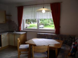 eine Küche und ein Esszimmer mit einem Tisch und einem Fenster in der Unterkunft Haus Waldfriede in Pertisau