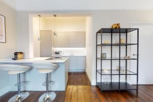 a kitchen with a counter and a shelf with stools at Super 1 Bedroom Flat in Hendon near Middlesex University with private parking in Hendon