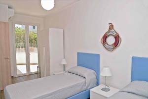 a bedroom with two beds and a clock on the wall at Altomare Case Vacanza in Porto Cesareo