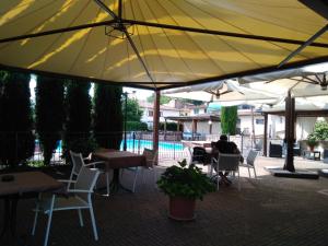 a person sitting at a table under a yellow umbrella at Parc Hotel in Poppi