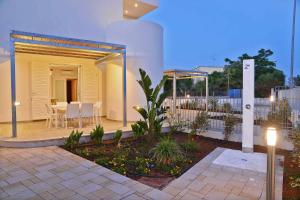 a patio of a house with a table and chairs at Altomare Case Vacanza in Porto Cesareo