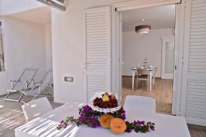 a white room with a table with a cake on it at Altomare Case Vacanza in Porto Cesareo