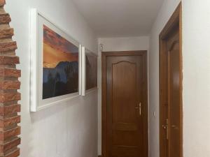 un couloir avec deux photos sur le mur et une porte dans l'établissement Finca Casa Mici, à Alhaurín el Grande