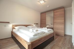 - une chambre avec un grand lit et des serviettes dans l'établissement Bergsonne, à Garmisch-Partenkirchen