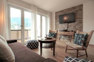 - un salon avec un canapé et une télévision sur un mur en briques dans l'établissement Bergsonne, à Garmisch-Partenkirchen