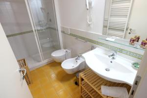 La salle de bains est pourvue d'un lavabo, d'une douche et de toilettes. dans l'établissement Rooms and Wine al Castello, à Monteriggioni