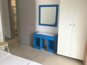 um armário azul com um espelho e uma mesa azul em Villa Maria em Kamariotissa