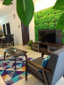 sala de estar con TV, sofá y mesa en Ken1606 Home - Centre of KB, WIFI, 6 to 8 pax en Kota Bharu