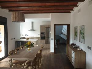 波索阿爾孔的住宿－Casa Rural Las Nueces，厨房以及带木桌和椅子的用餐室。