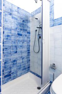 bagno con doccia e piastrelle blu di CASA VACANZE AULIV MATINO a Mattinata