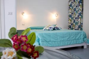 un letto con lenzuola e cuscini blu in una stanza di CASA VACANZE AULIV MATINO a Mattinata