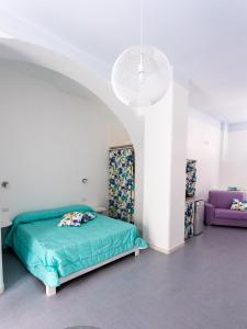 a bedroom with a green bed and a purple couch at CASA VACANZE AULIV MATINO in Mattinata