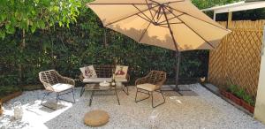 a patio with two chairs and a table with an umbrella at Villa Noemi Bed&Breakfast in Pisa