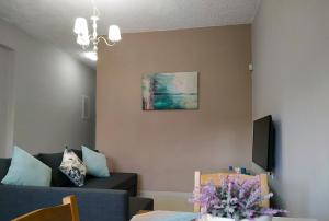 a living room with a couch and a vase of flowers at Amaryllis Boutique Apartments in Moraitika
