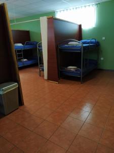 a room with three bunk beds and a tile floor at Albergue O Bordón in Cee