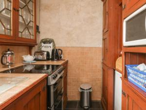 a small kitchen with a stove and a sink at The Pend in Newton Stewart