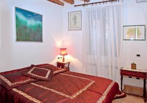 ein Schlafzimmer mit einem Bett, einer Lampe und einem Fenster in der Unterkunft Casa a San Marco in Venedig
