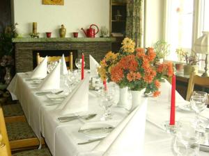 einen Tisch mit einem weißen Tischtuch und Blumen darauf in der Unterkunft Panoramahotel Alde Hotz GbR in Görwihl