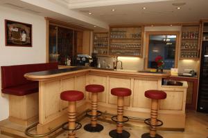 a bar in a restaurant with stools at a counter at Hotel Garni Sonnenheim in Fiss