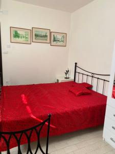 a bedroom with a red bed with two pictures on the wall at Anči in Pula