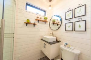 ein Bad mit einem Waschbecken und einem Spiegel in der Unterkunft The Woods- Container Tiny House 12 min to Magnolia/Baylor/Downtown in Bellmead