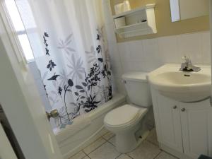 a white toilet sitting next to a bathroom sink at Flamingo Motel in Penticton