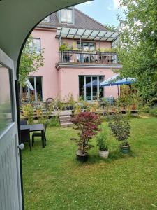 a house with a yard with potted plants and a patio at Schaferwagen in Kassel
